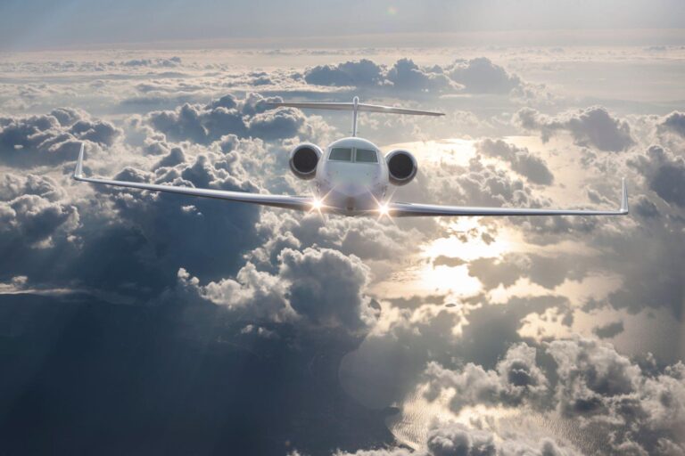 Private jet cruising above the clouds during golden hour sunlight