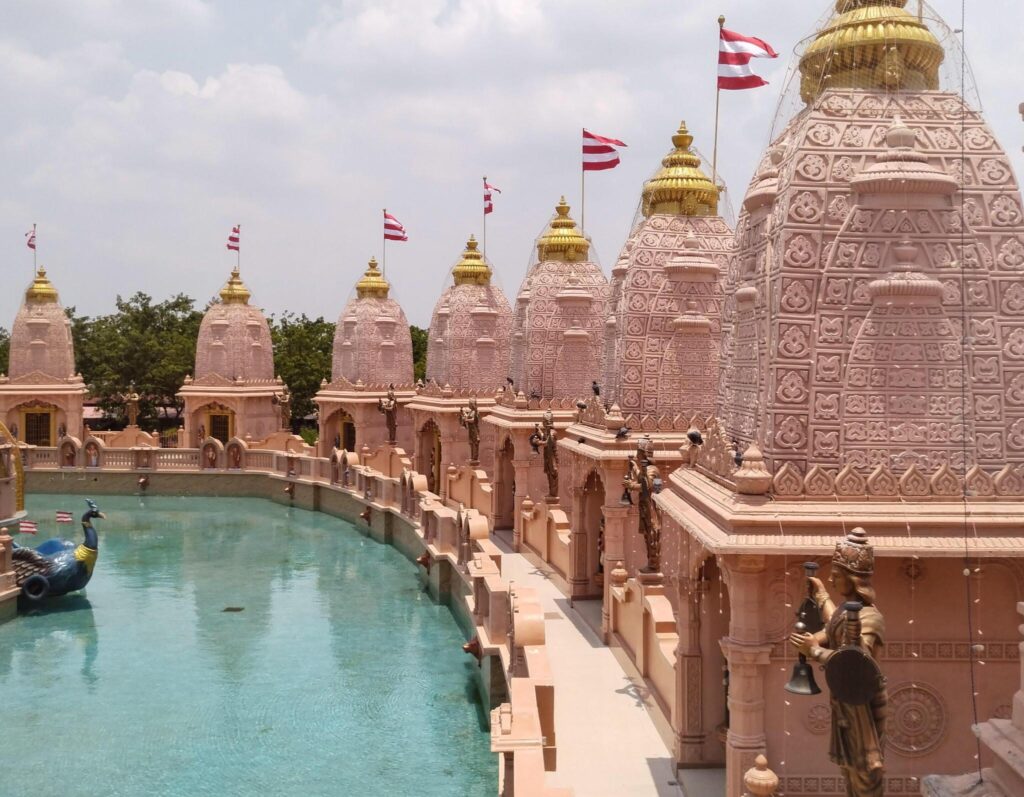 Ram temple complex in Ayodhya with pink sandstone architecture and a serene water body