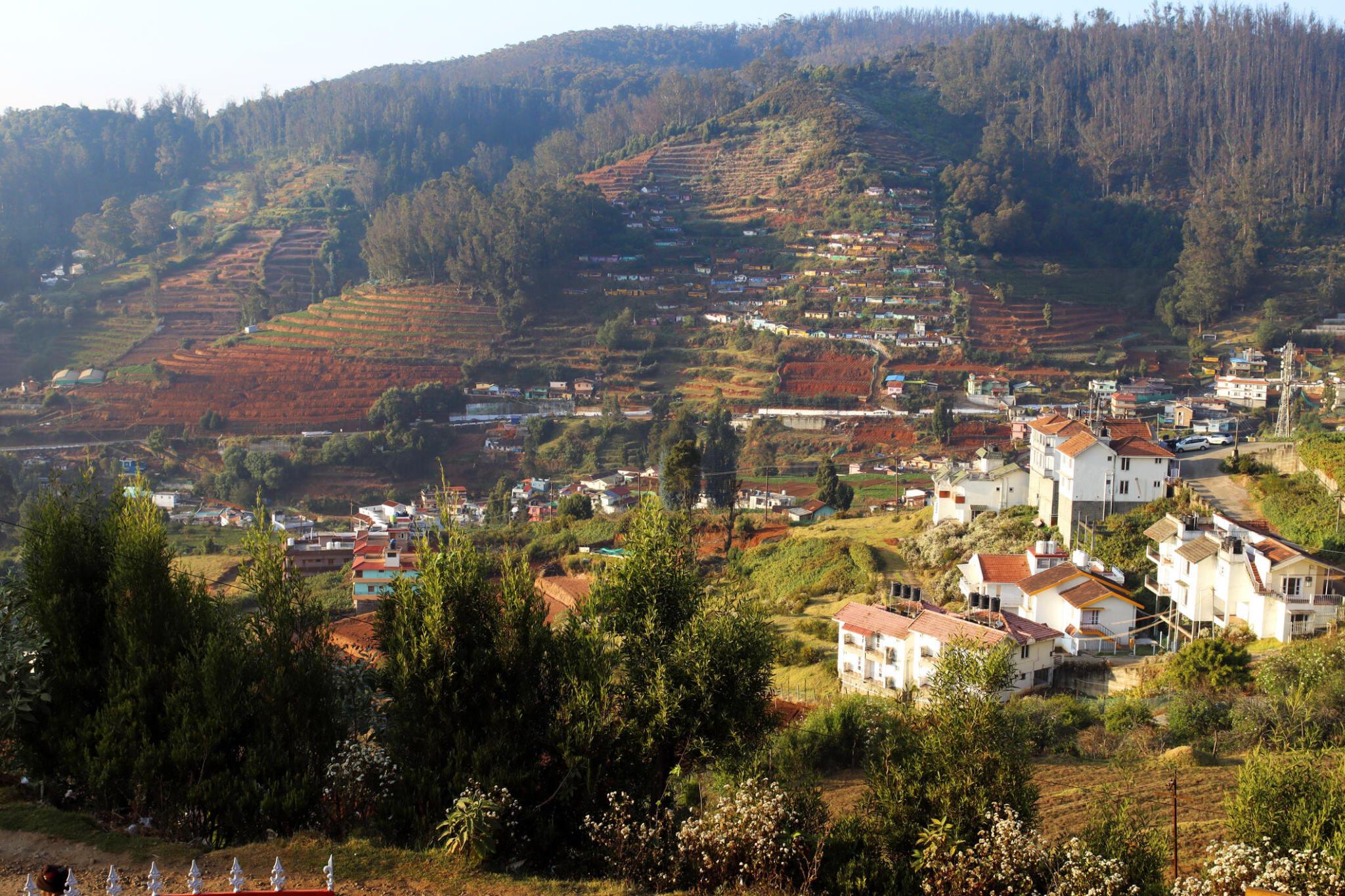View of green hills with scattered houses and plantations near Coimbatore, Tamil Nadu