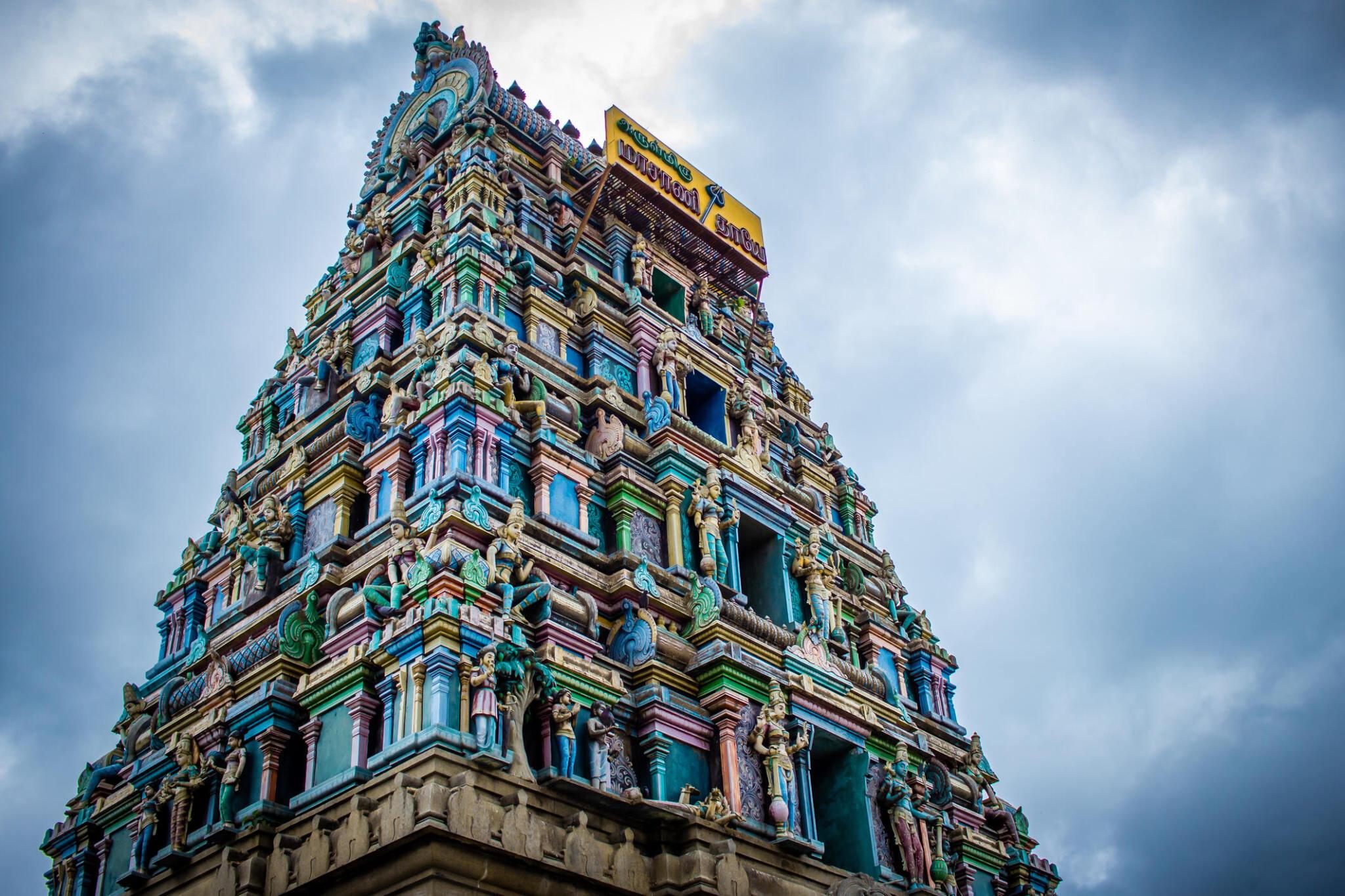 Detailed view of the colorful temple tower in Coimbatore and a panoramic landscape of hills and houses in Coimbatore