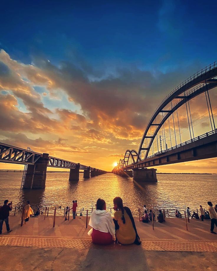 People watching sunset over the Godavari River near the iconic Godavari Bridge in Rajahmundry, India