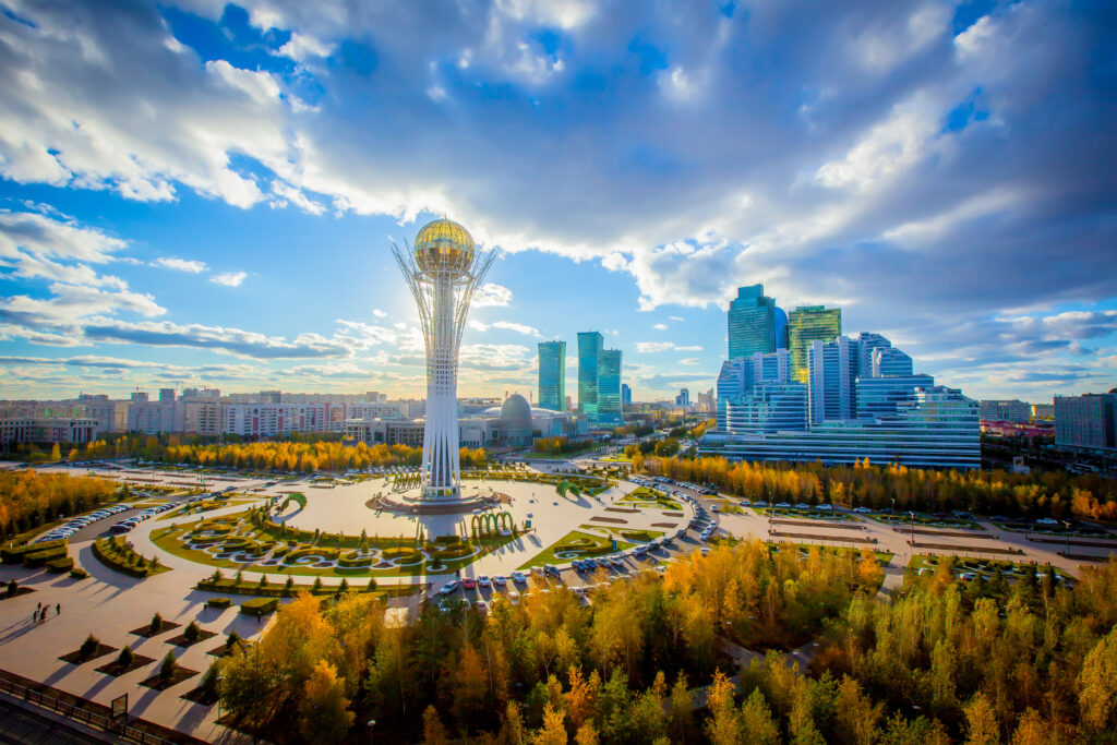 View of Baiterek Tower and modern skyscrapers in Astana, Kazakhstan during sunset