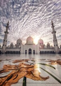 Sheikh Zayed Mosque courtyard under dramatic cloudy sky