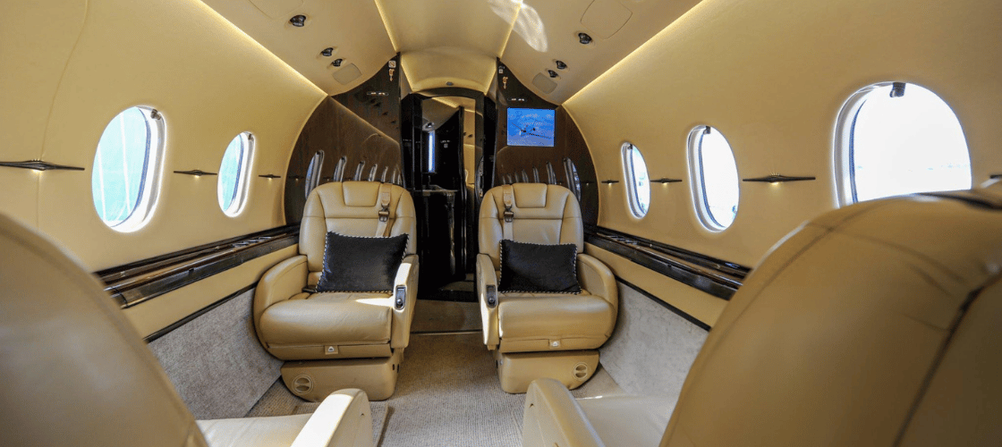 Luxurious interior of a 4-seater private jet with leather seats and plush pillows